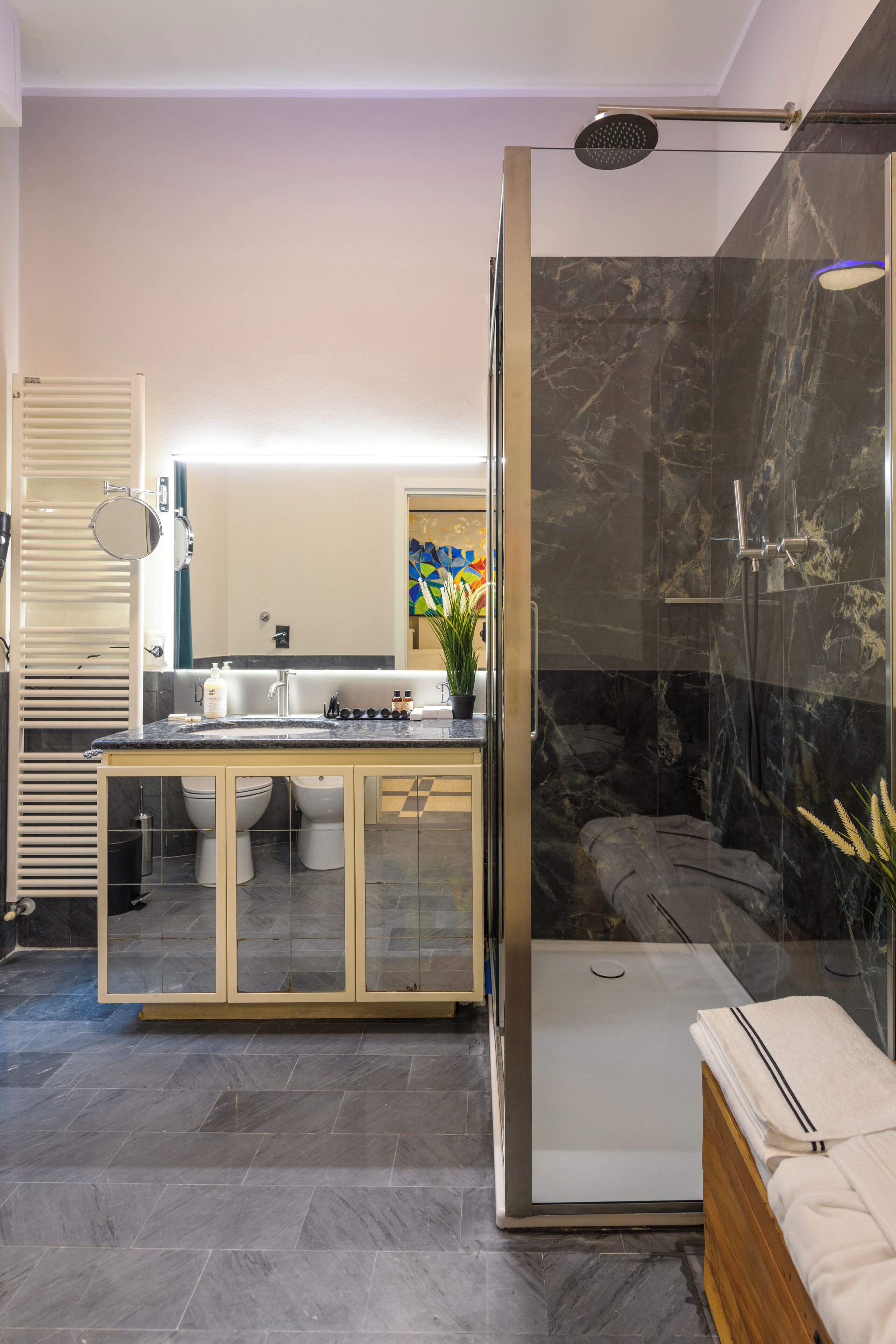 A modern bathroom with a glass-enclosed shower, a vanity with a mirror, and a toilet.