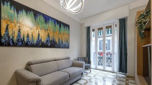 A living room with a grey sofa, a large abstract painting, and a checkered floor. - DibraLuxurySuites (Milan)