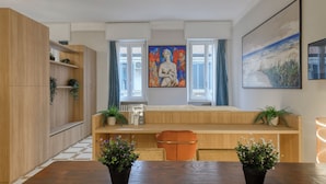A modern kitchen with wooden cabinets, a built-in bench, and two potted plants. - DibraLuxurySuites (Milan)