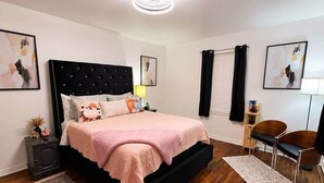 A bedroom with a bed, bedside tables, a chair, a rug, and artwork on the walls. - Waggoner in Longview (Longview)