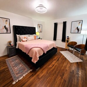 A bedroom with a bed, bedside tables, a chair, a rug, and artwork on the walls. - Waggoner in Longview (Longview)