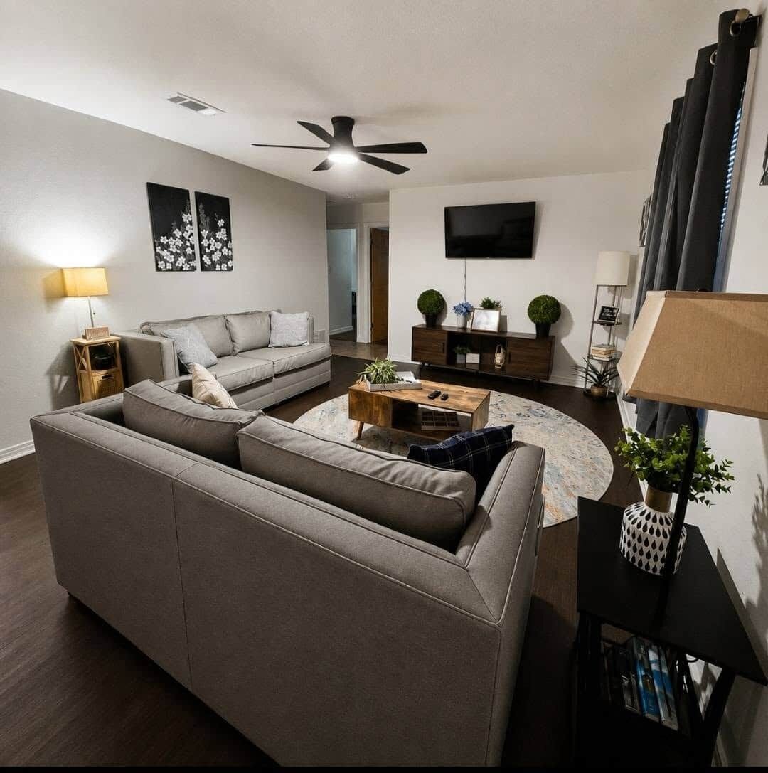 A modern living room with a sofa, coffee table, and a ceiling fan.
