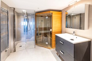 Ein modernes Badezimmer mit einer gläsernen Duschkabine, einem Holzbadezimmer-Möbel und einem großen Spiegel.