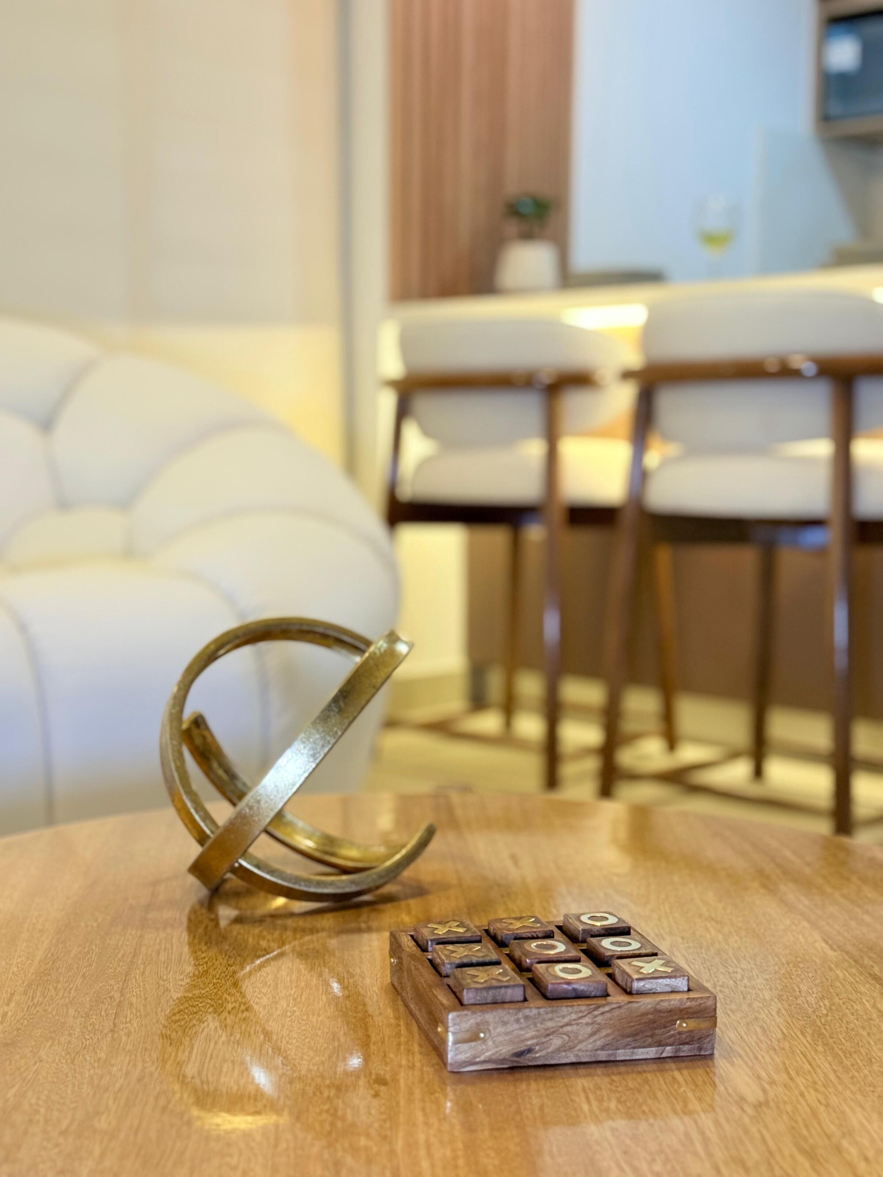 Uma mesa de madeira com um jogo de blocos de madeira e uma escultura de metal.
