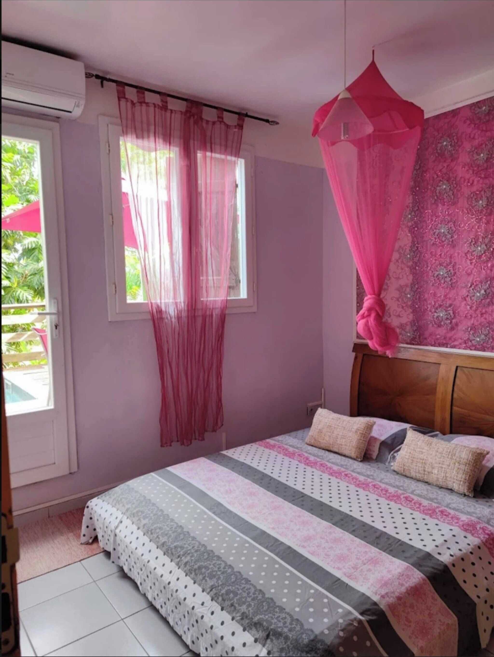Une chambre à coucher avec un lit, des rideaux et une fenêtre.