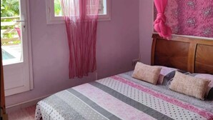 A bedroom with a bed, curtains, and a window. - Appartement Hibiscus - Ground floor (Le Moule)