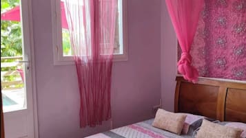 Une chambre à coucher avec un lit, des rideaux et une fenêtre.