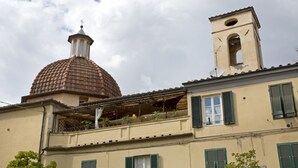 A building with a dome, a bell tower, and a balcony with potted plants. - Casa San Girolamo, historic flat with terrace in Lucca's City Center (Lucca)