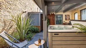 A modern outdoor area with a hot tub, a wooden table, and a lounge chair. - Truffe - Confort 2 - 5p (Saint-Geniès)