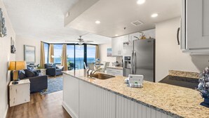 Eine moderne Küche mit einer Granit Arbeitsplatte, Edelstahlgeräten und Meerblick.