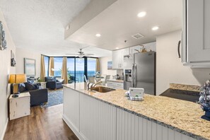 Eine moderne Küche mit einer Granit Arbeitsplatte, Edelstahlgeräten und Meerblick.