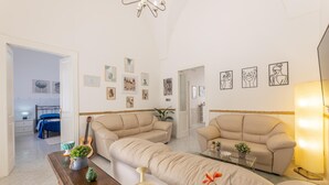 A living room with two beige sofas, a wooden coffee table, and a chandelier. - Villa Levante - Taviano (Taviano)