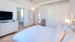 A bedroom with a large bed, a television, a dresser, and a chair. - 4 bed Prestigious Luxury Villa, Royal Westmoreland (Lancaster)