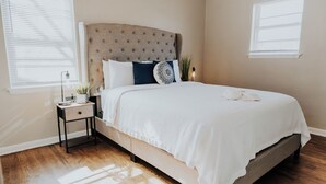 Une chambre à coucher avec un lit, une table de chevet et une lampe de chevet.