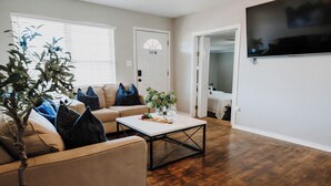 Un salon avec un canapé beige, une table basse et une plante en pot.
