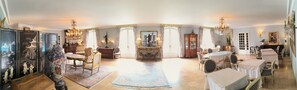 A spacious room with a large chandelier, ornate furniture, and a view of the outdoors. - DORDOGNE VACATION RENTALS (Thiviers)