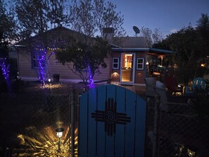 Una casa con antena parabólica, un pequeño porche y un portón con un símbolo nativo americano.
