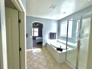 A modern bathroom with a glass shower enclosure, a built-in sink, and a large window providing natural light. - Luxury Desert Oasis (Phoenix)