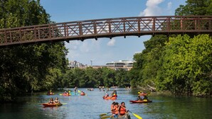 Une rivière où des personnes pratiquent le kayak sous un pont.
