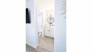 Une salle de bain moderne avec des toilettes, un lavabo et un miroir.