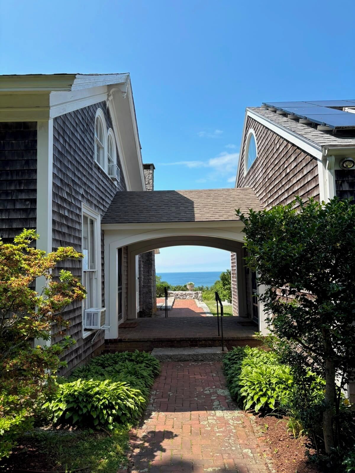 A pathway leading to a house with a view of the ocean.