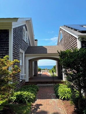 A pathway leading to a house with a view of the ocean. - Oceanside Estate: Main House & Apt w/beach access (Gloucester)