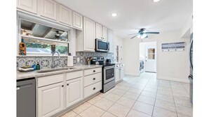 A kitchen with white cabinets, a microwave, an oven, and a dishwasher. - Winter snowbirds retreat- Monthly discount available for min 3 month stay (Gulf Breeze)