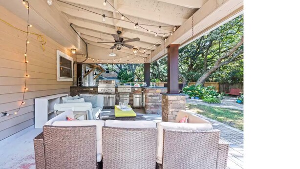 An outdoor patio with wicker furniture, string lights, and a barbecue grill. - Winter snowbirds retreat- Monthly discount available for min 3 month stay (Gulf Breeze)