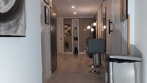 A modern hallway with a central seating area, a trash bin, and framed artwork on the walls. - Serene 2-bedroom apartment in Calgary, perfect for your getaway- The Loft Modern (Calgary)