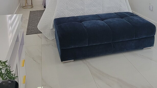 Una camera da letto moderna con un letto, una TV, un comodino e una grande finestra.