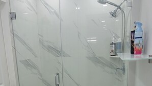 Un bagno moderno con doccia vetro, un water e un bidet.