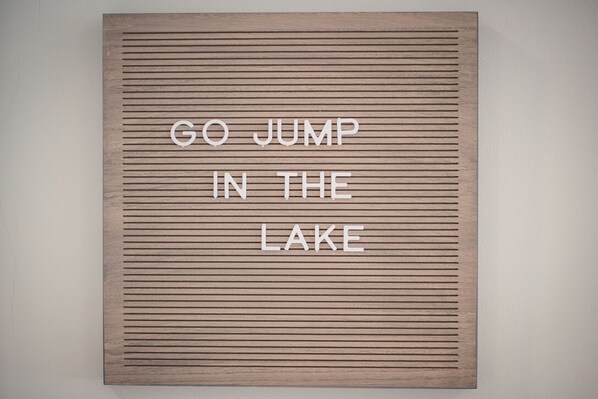 Ein hölzernes Schild mit der Aufschrift 'GO JUMP IN THE LAKE'.