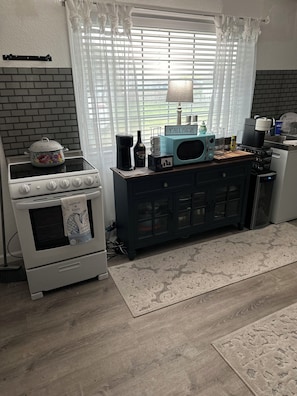 Eine Küche mit Herd, Mikrowelle und Schrank.