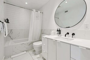 Ein modernes Badezimmer mit Badewanne, Toilette und Waschbecken.