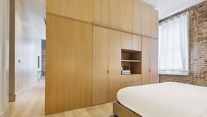 Ein Schlafzimmer mit einem großen Bett, einem Holzschrank und einer Ziegelwand.