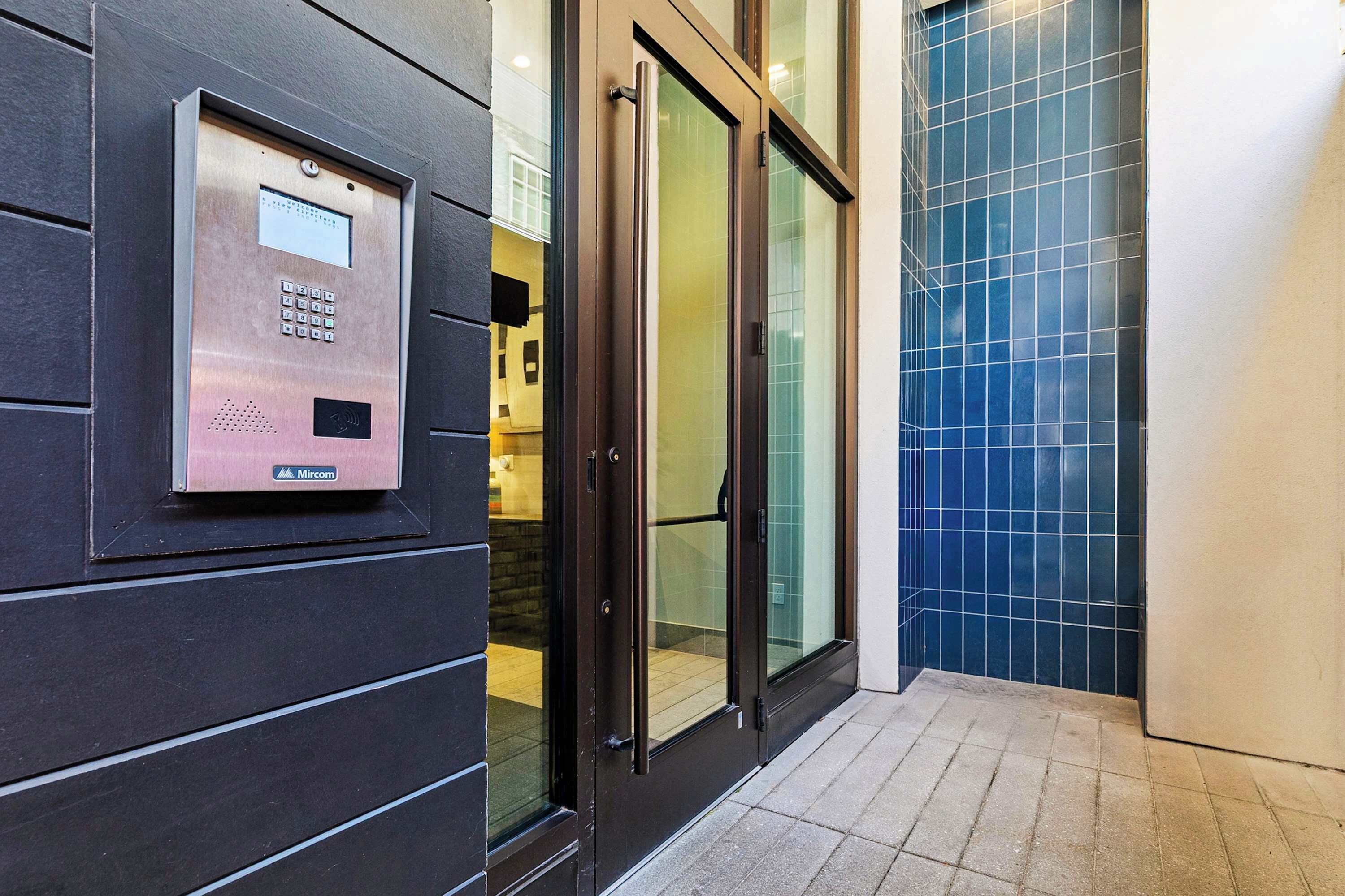 Un ascenseur moderne doté d’un panneau de commande, de portes en verre et d’un sol carrelé.
