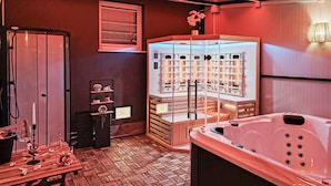 Ein Wellnessraum mit Whirlpool, Massageliege und Sauna.
