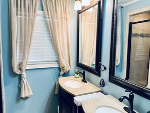 A bathroom with two sinks, a mirror, and a window with curtains. - Getaway Hideway (Thomasville)