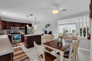 A modern kitchen with dark wood cabinets, stainless steel appliances, and a central island.