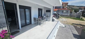 A modern house with a balcony, a dining area, and a staircase leading to the upper floor.