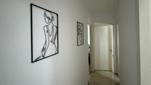 A hallway with two framed artworks on the walls.