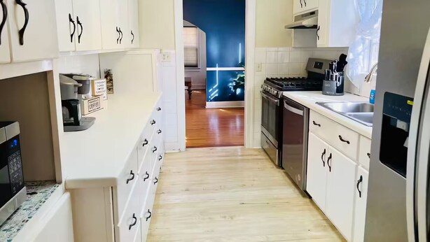 Een moderne keuken met witte kasten, een fornuis en een koelkast.