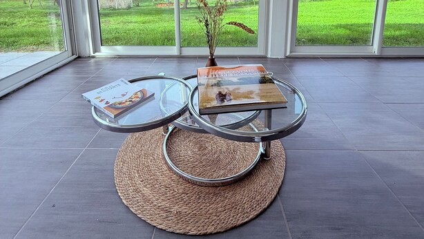 Een ruime kamer met een grote glazen deur die uitkomt op een groen terras.