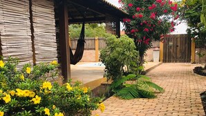 A brick pathway leading to a wooden structure with a corrugated metal roof.