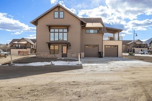 A two-story house with a garage, a covered porch, and a driveway.
