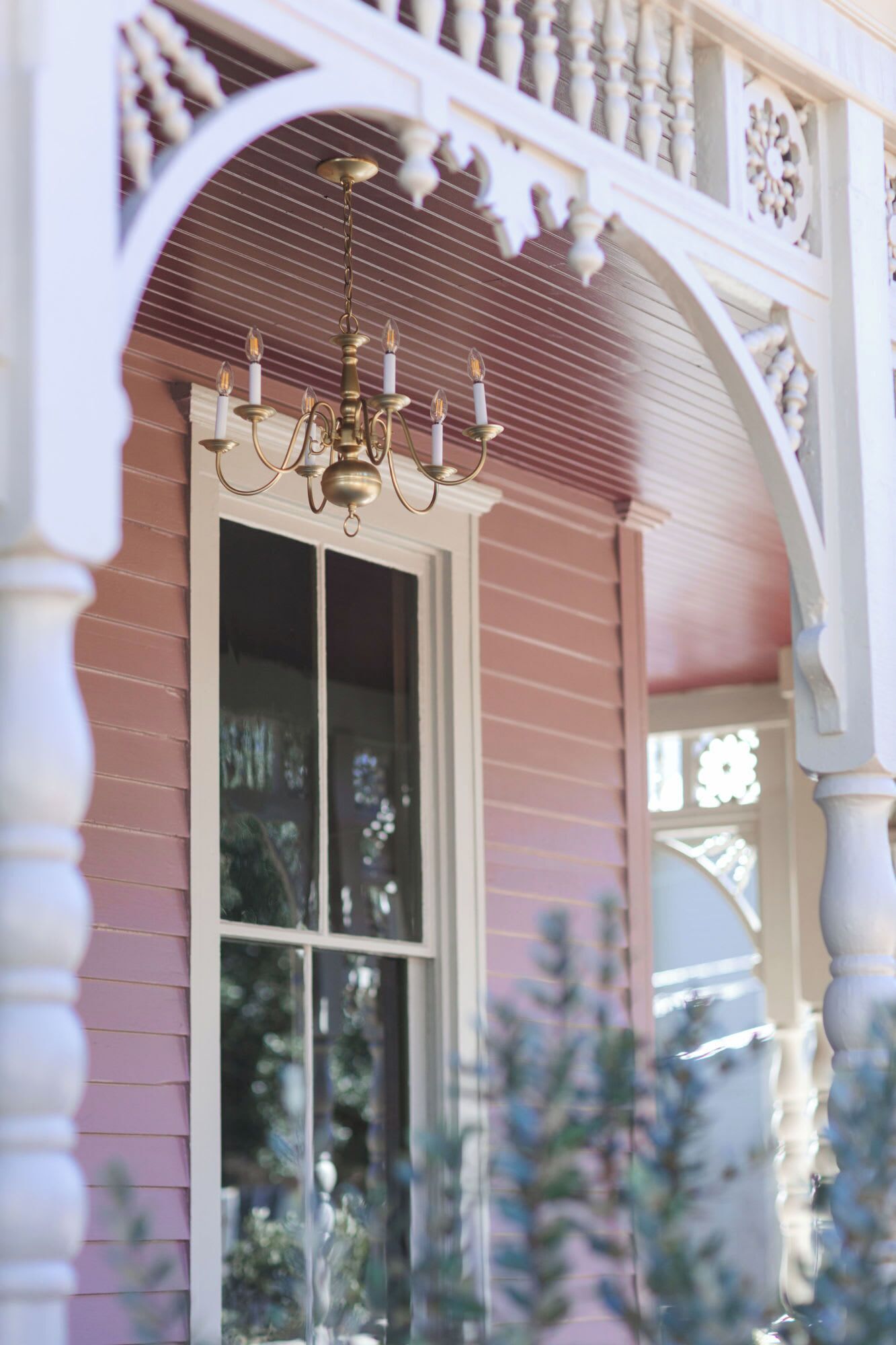 Ein traditionelles Haus mit einer weißen Veranda und einem großen Fenster.