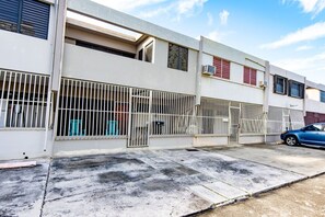 Ein Gebäude mit einem ehrverfüllten Eingangsbereich und einem draußen geparkten blauen Auto unter blauem Himmel.