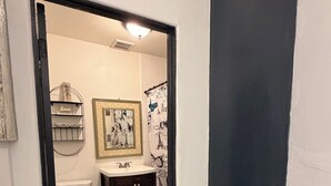 A bathroom with a toilet, sink, and dark wooden cabinet. - Cozy studio in Lancaster (Lancaster)