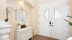A room with a white vanity, a large mirror, and a double door with glass panels. - Temecula Wine Country Hilltop Estate – 360° Views & Heavenly Sunsets (Temecula)