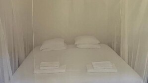 A room with a bed, two pillows, and folded towels. - Cozy 1-Bedroom Apartment with Terrace and Pool in Bensafrim (Bensafrim)
